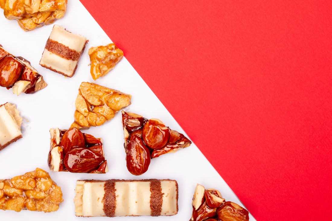 Assortment of nuts and chocolate bars on white background