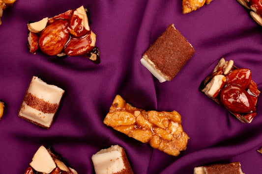 Assortment of nuts and chocolate bars on purple fabric