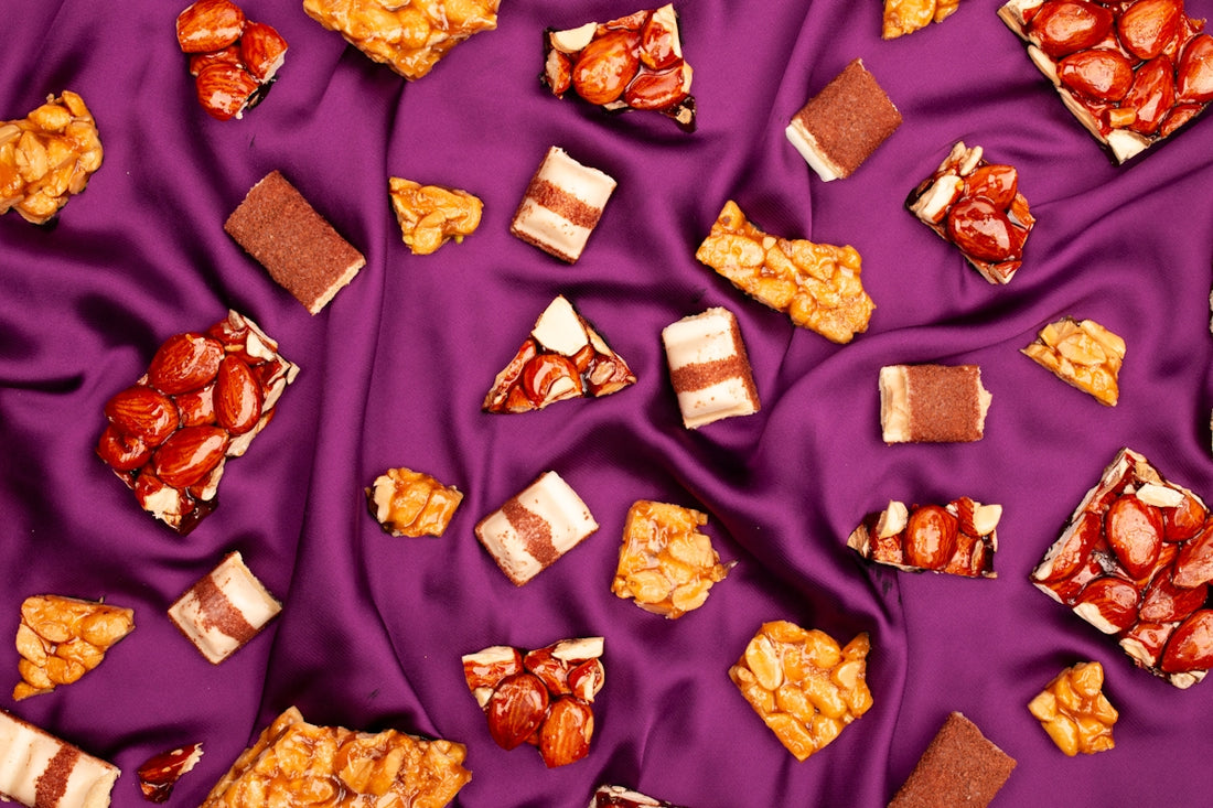 Assorted candy bars and peanut brittle on purple fabric
