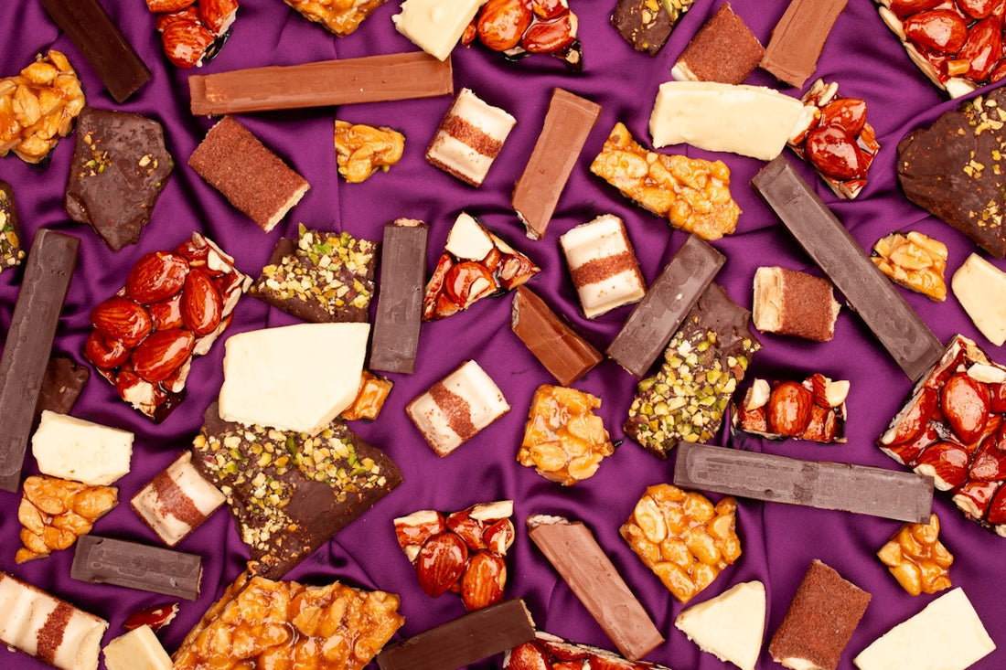 Assortment of chocolate bars and candies on purple fabric
