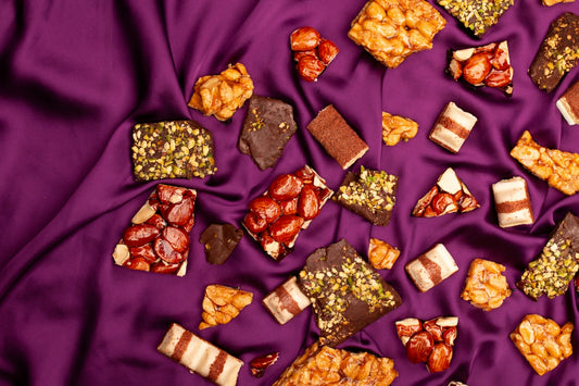Assorted sweets and chocolates scattered on purple silk