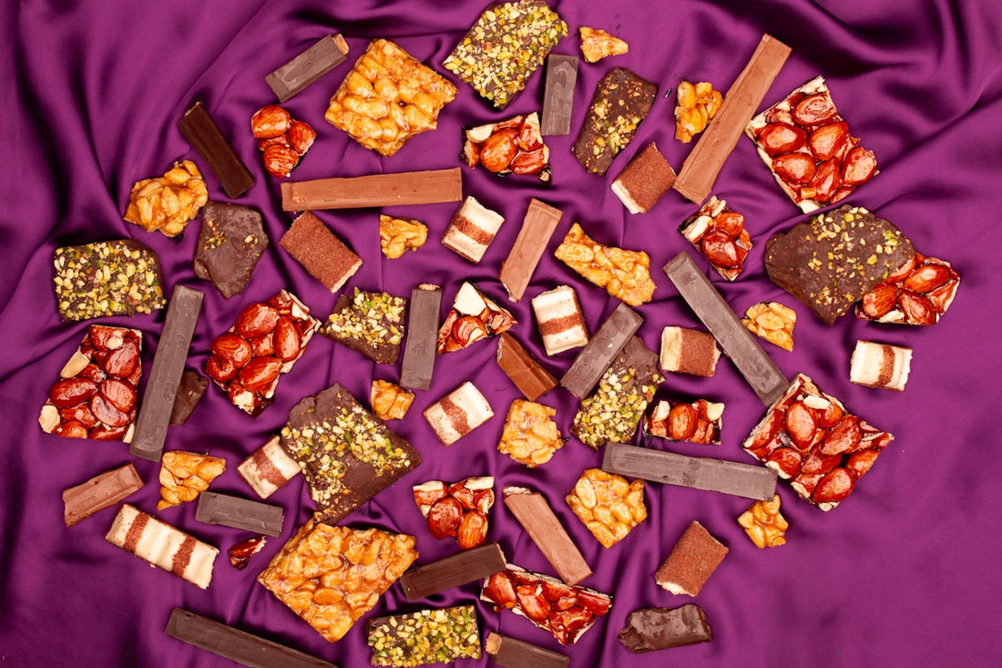 Assortment of chocolate bars and candies on purple satin