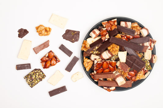 Assortment of chocolate bars and nutty treats on a plate.