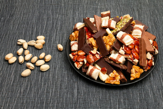 A pile of assorted chocolate bars and pistachios