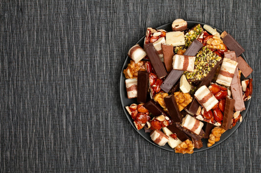 A dark plate filled with assorted chocolates and nuts