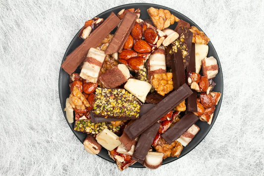 A variety of chocolate bars and nuts on a plate